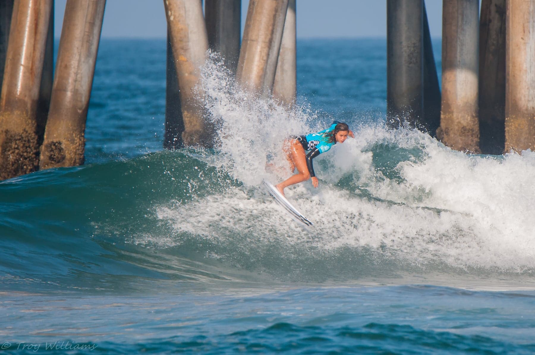 Alessa riding a wave beside Huntington Beach pier. Example photography by Troy Williams.